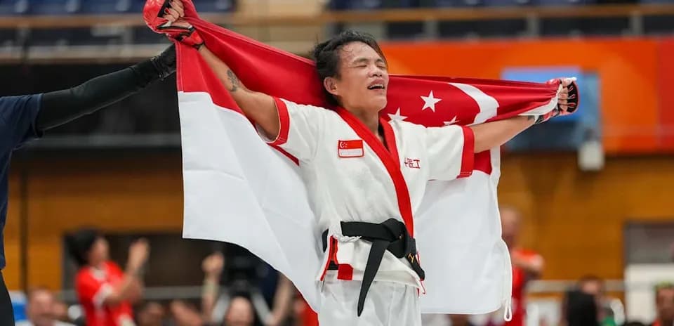 Martial artist celebrating with Singapore flag after victory