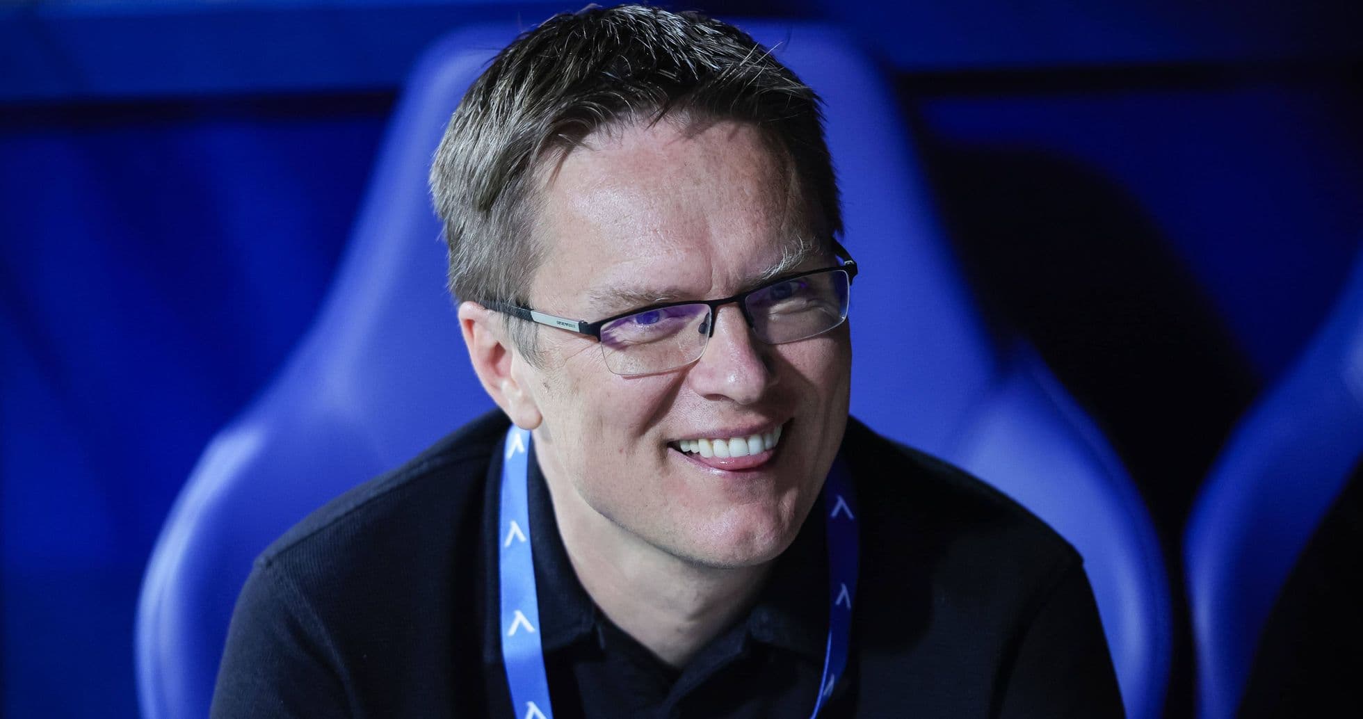 Man smiling in a sports venue seating area