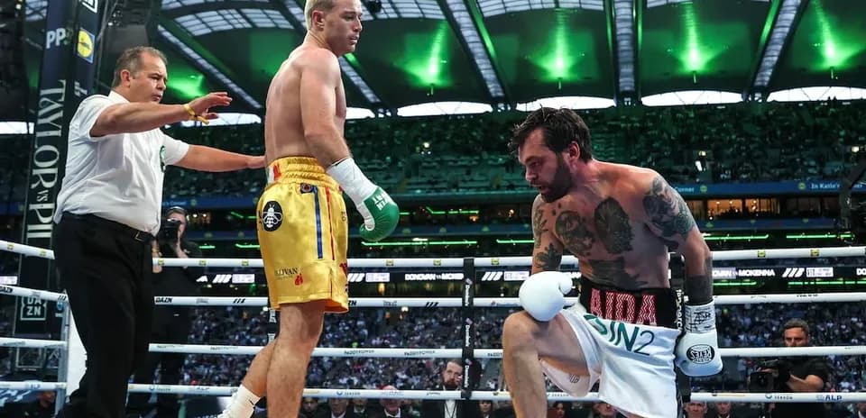 Boxer kneeling in ring with referee overseeing