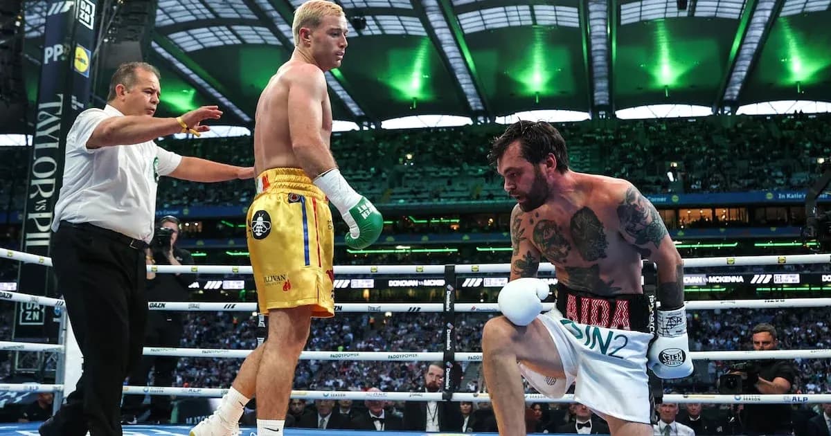 Boxer kneeling in ring with referee overseeing Boxer kneeling in ring with referee overseeing