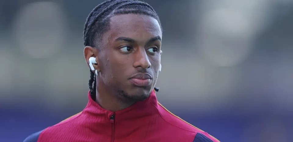Player wearing red training jacket with earbuds