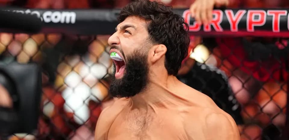 Fighter celebrating with mouthguard in octagon