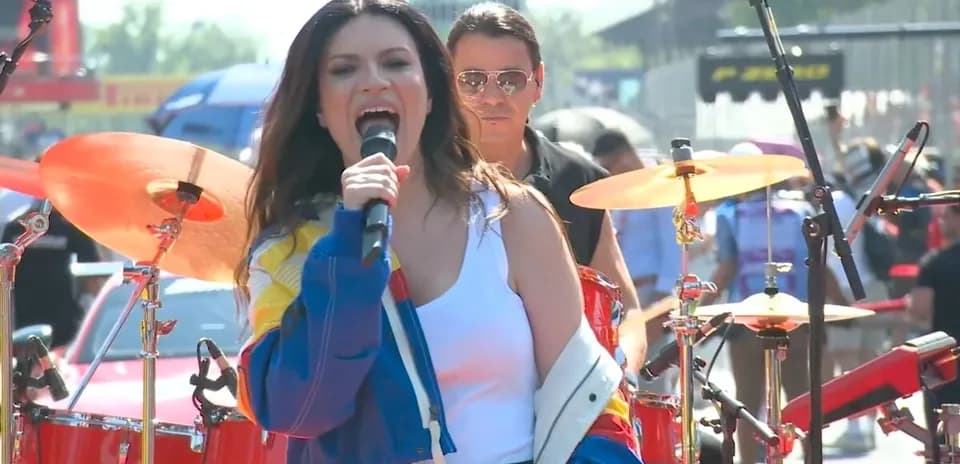 Singer performing with a band at outdoor event
