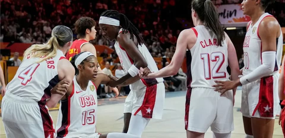Team USA players assisting teammate on court
