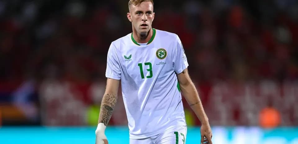 Player in white jersey walking on field during match