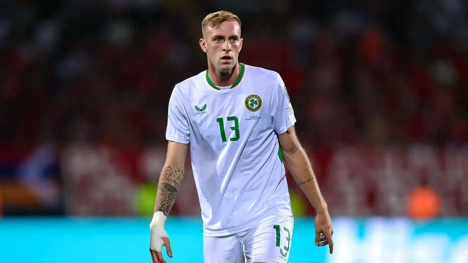 Player in white jersey walking on field during match Player in white jersey walking on field during match