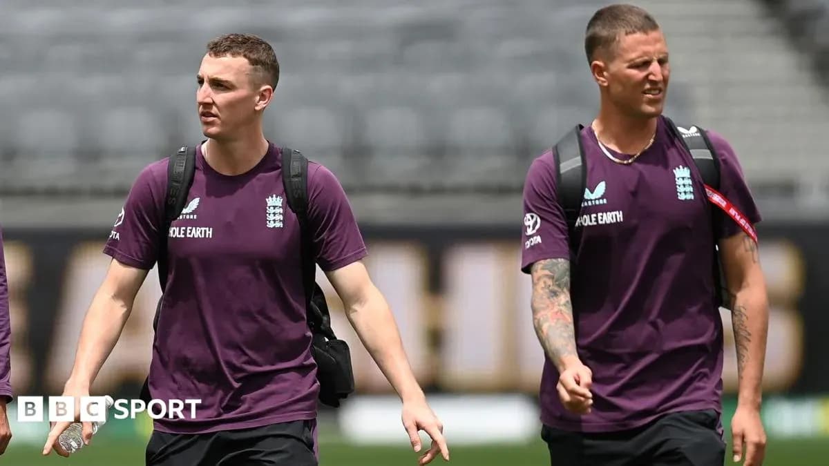 Two England cricket players walking on field
