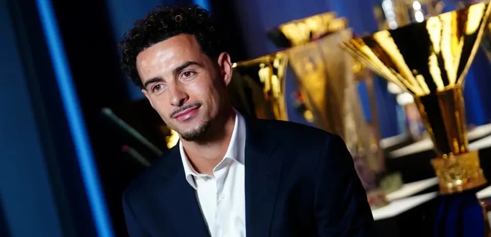 Person in suit with trophies in background