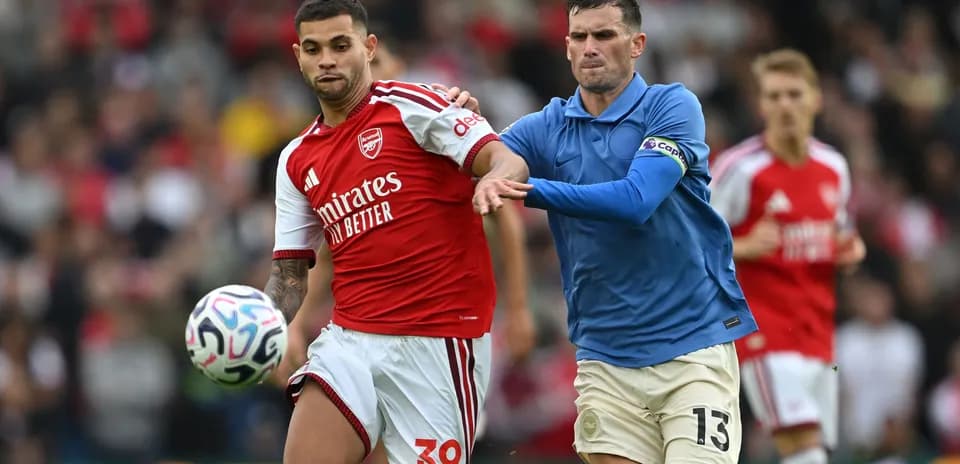 Player in red jersey evading opponent in blue jersey