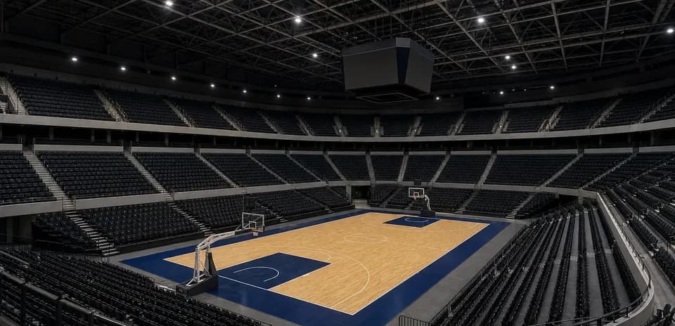 Empty basketball arena with wooden court and bleachers