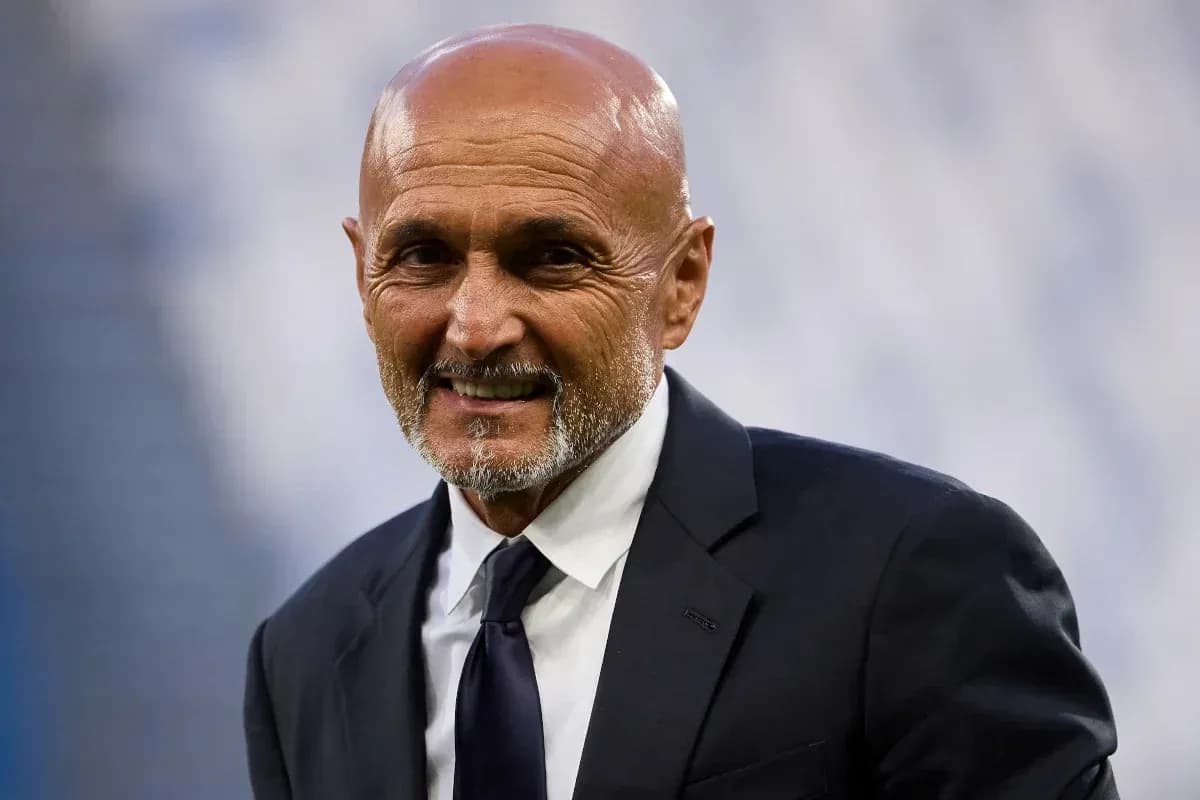 Coach smiling in formal attire at stadium