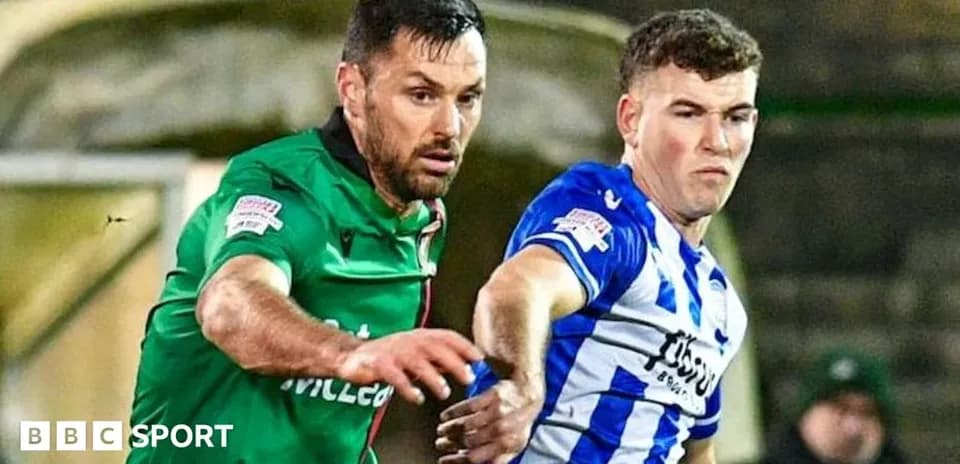 Two football players contesting for the ball