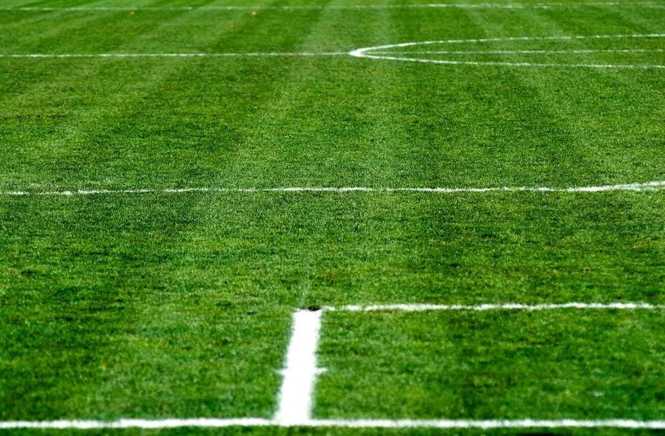 Close-up of a green football pitch with markings