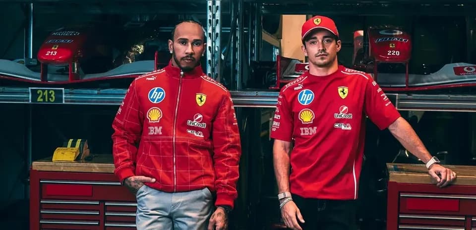 Two drivers in Ferrari team uniforms posing in garage