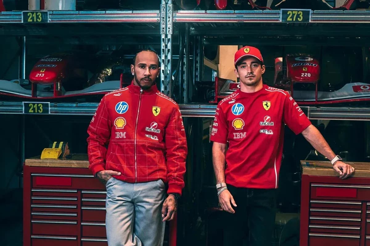 Two drivers in Ferrari team uniforms posing in garage
