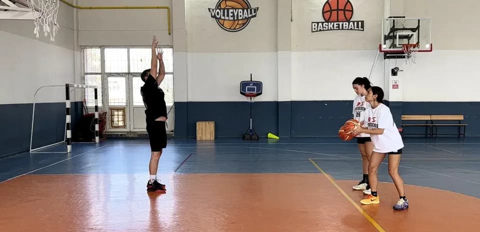 Player practicing shooting while two teammates watch