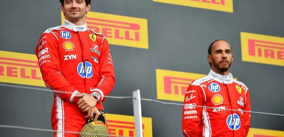 Two Formula 1 drivers on podium celebrating victory