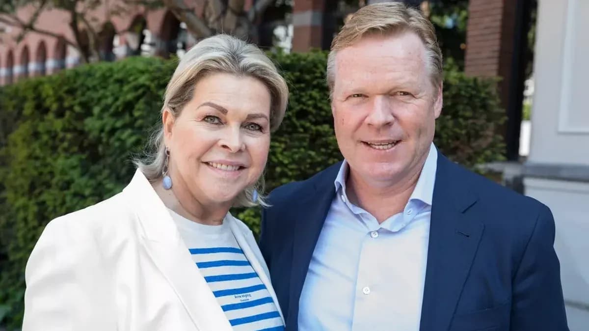 Two people posing outdoors in front of greenery