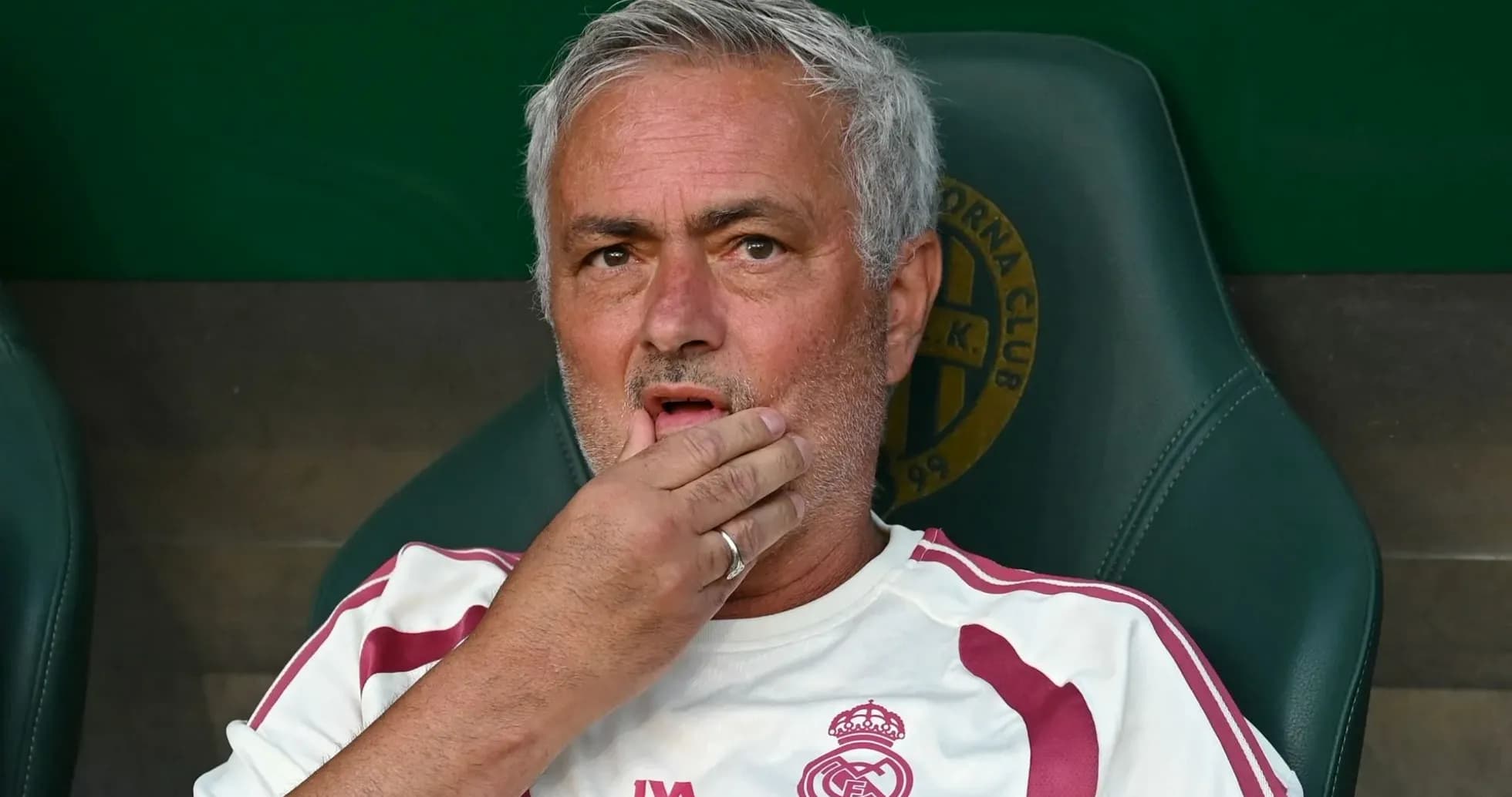 Coach sitting on bench with hand on chin