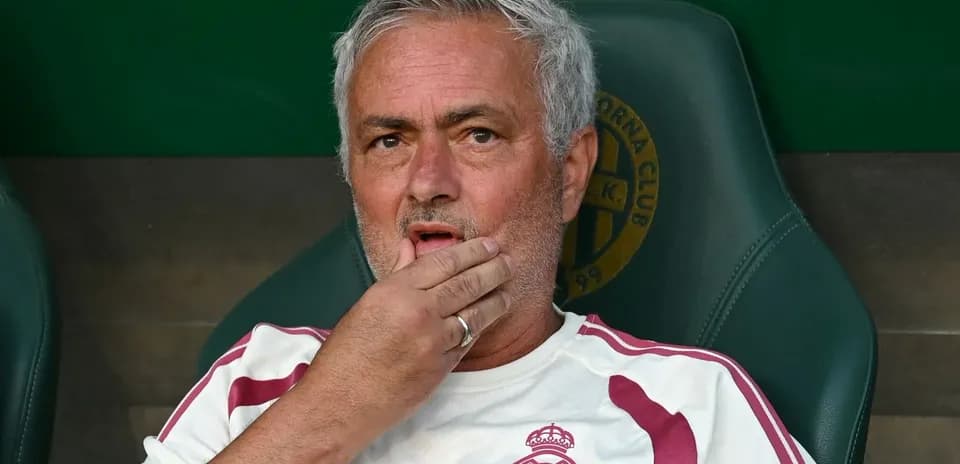 Coach sitting on bench with hand on chin
