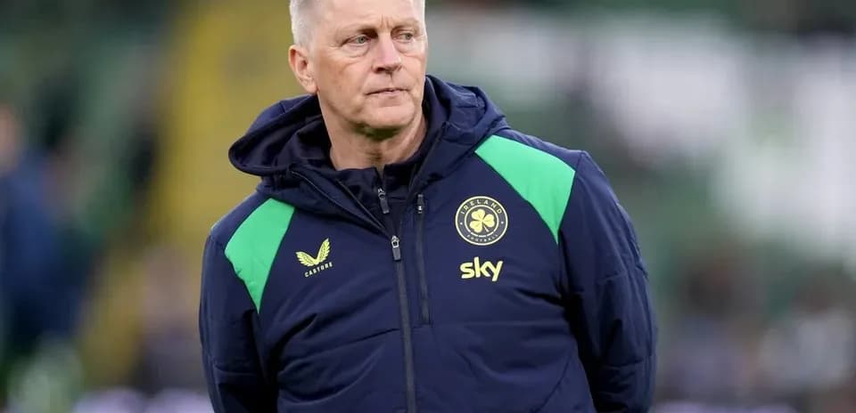 Coach in jacket observing on the pitch