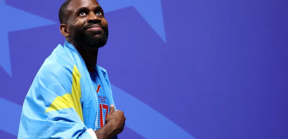 Athlete wearing a flag, looking upwards on stage