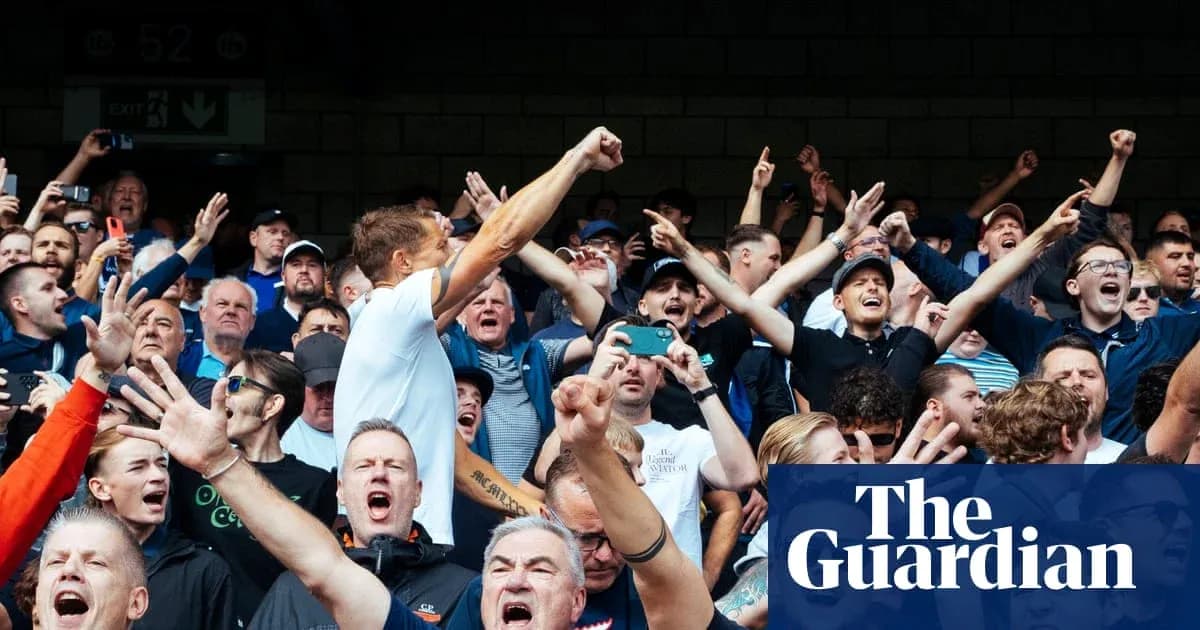 Crowd of fans cheering passionately at a sports event