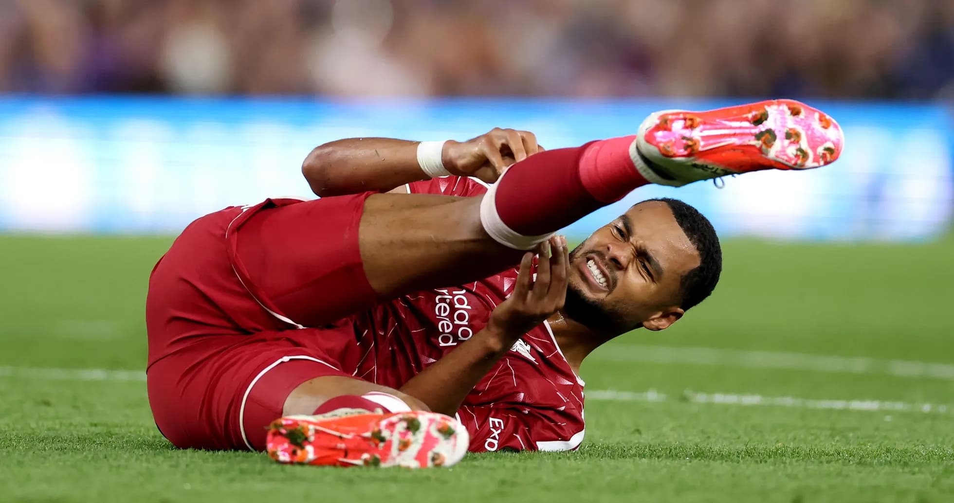 Player lying on pitch holding injured leg