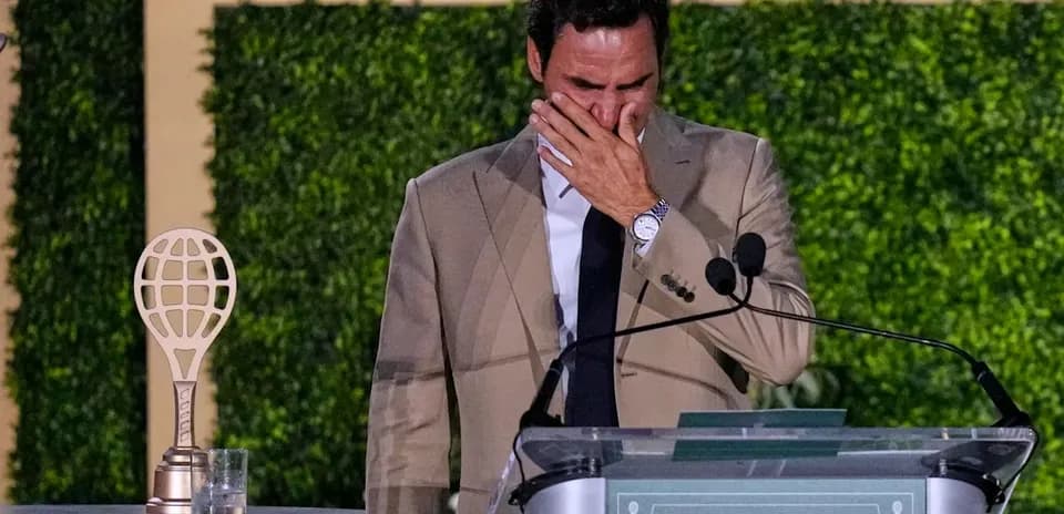 Tennis player speaking at a podium with trophy
