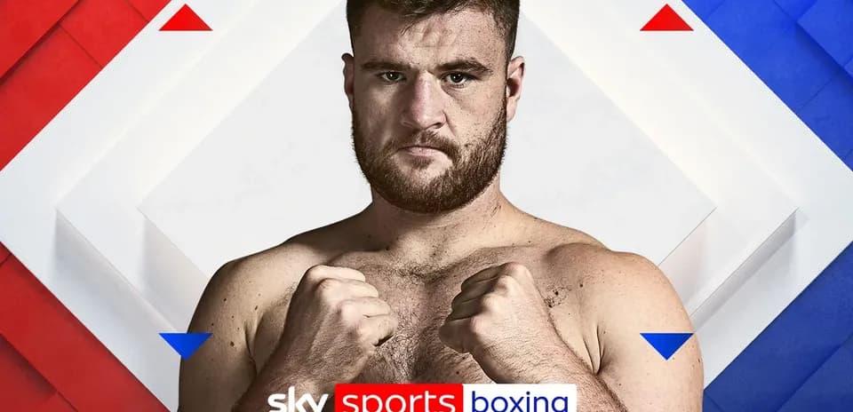 Boxer posing with fists raised against backdrop