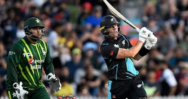 Batsman hitting the ball while wicketkeeper observes Batsman hitting the ball while wicketkeeper observes