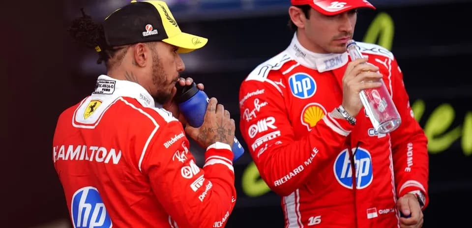Two Formula 1 drivers drinking from bottles