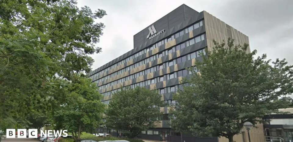 Marriott hotel building with trees and parking area
