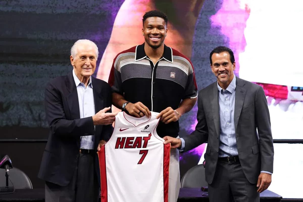 Player holding Miami Heat jersey with team officials