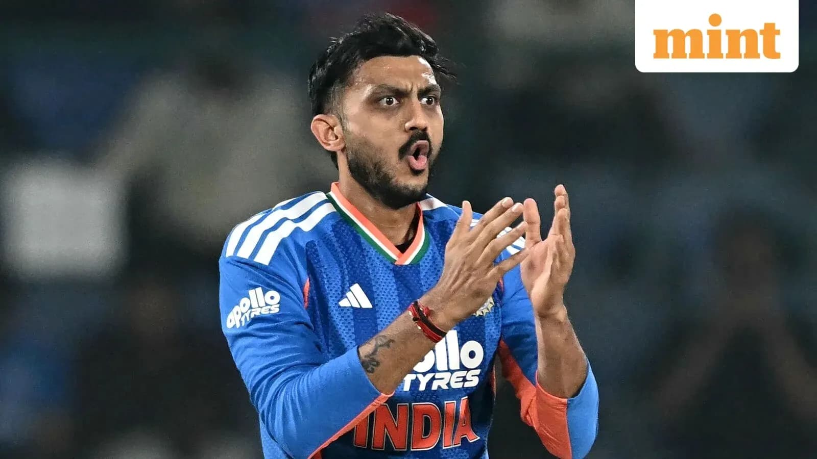 Cricketer gesturing during match in blue jersey