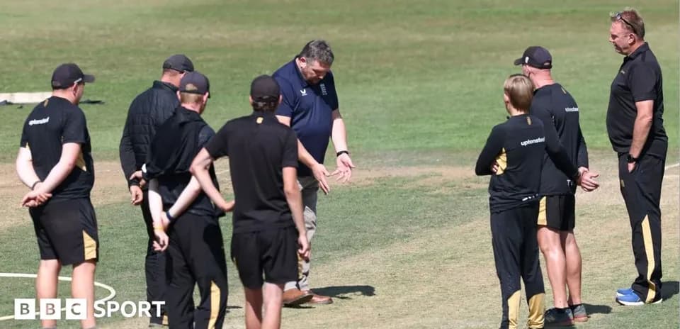 Coaches discussing strategy during cricket training session