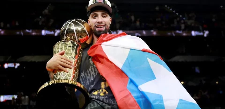Player holding championship trophy and flag