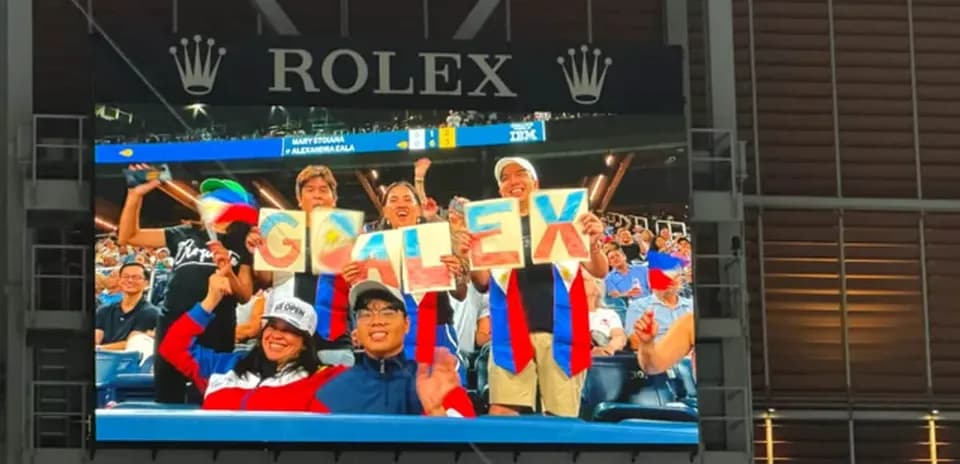 Fans holding signs spelling 'GO ALEX' in stadium