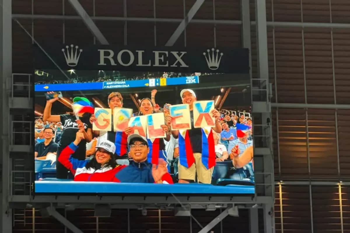 Fans holding signs spelling 'GO ALEX' in stadium