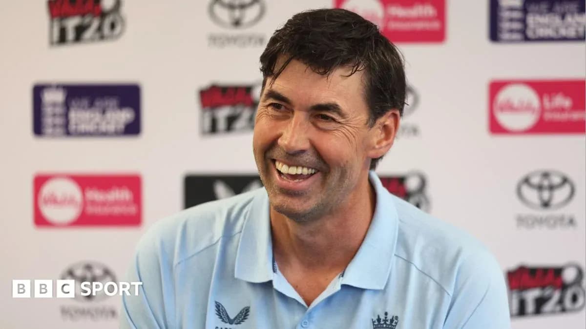 Cricket coach smiling at press conference Cricket coach smiling at press conference