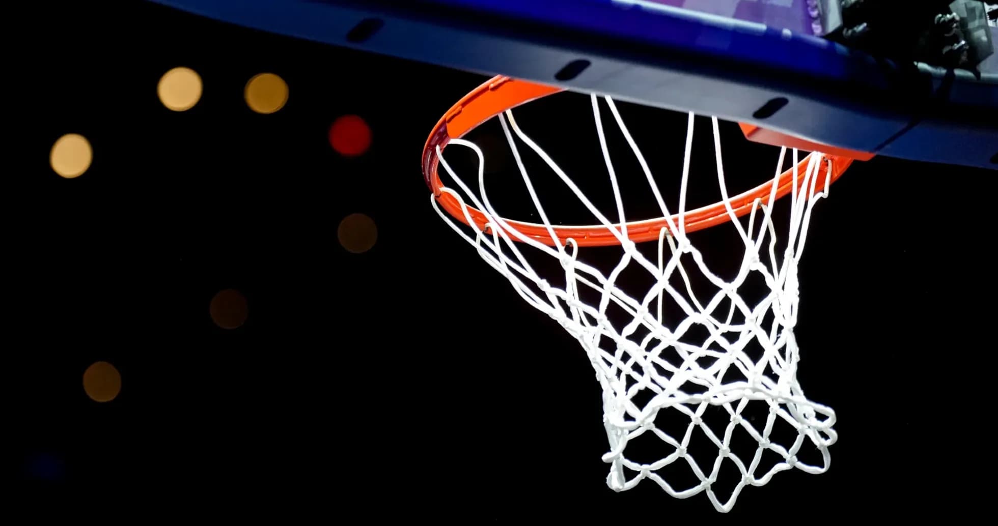 Close-up of basketball hoop against dark background