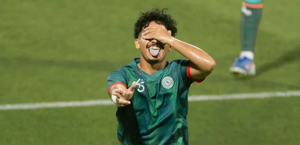 Player celebrating with hand over face on field