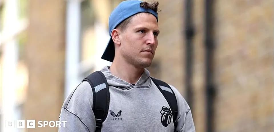 Man wearing a cap and hoodie walking outdoors
