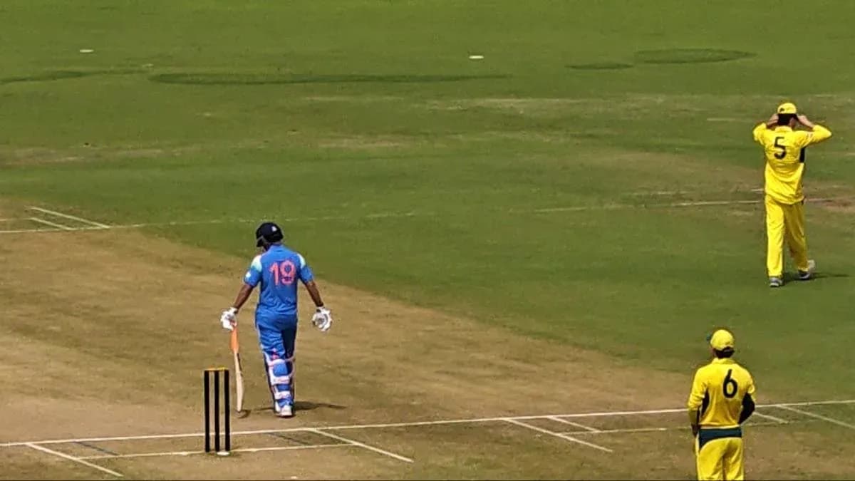 Batsman in blue uniform walking to crease