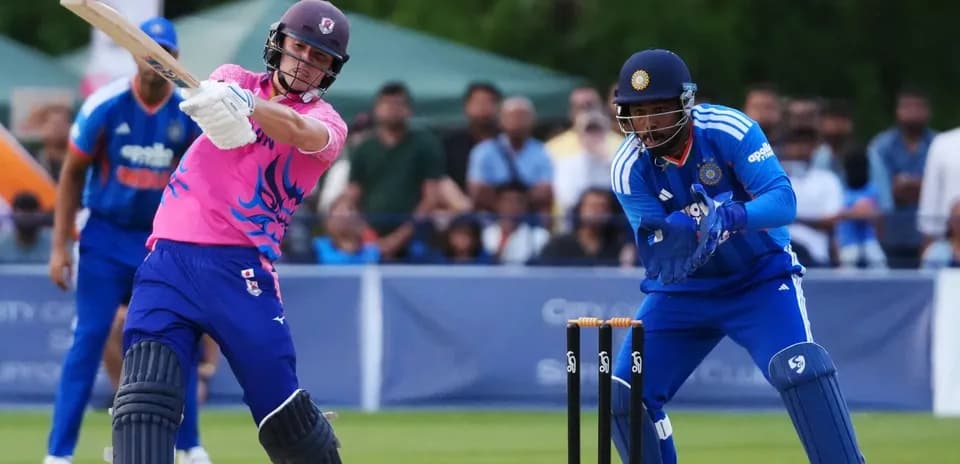 Batsman hitting ball while wicketkeeper prepares to catch