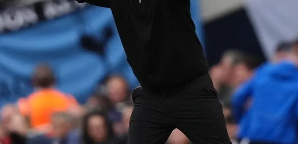 Coach gesturing during a football match on the sidelines