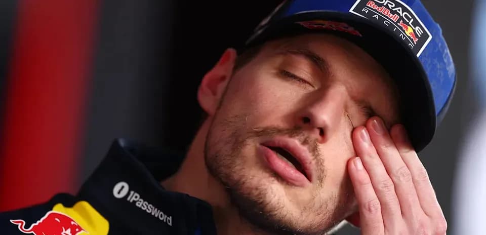 Driver resting hand on face during press conference