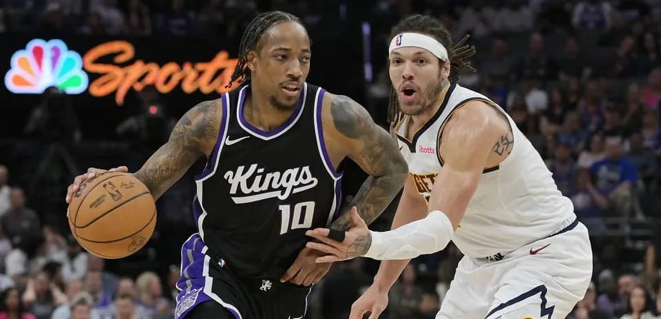 Player dribbling basketball while being closely defended