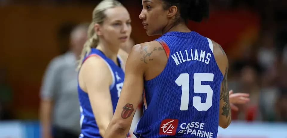 Two basketball players in team jerseys on court