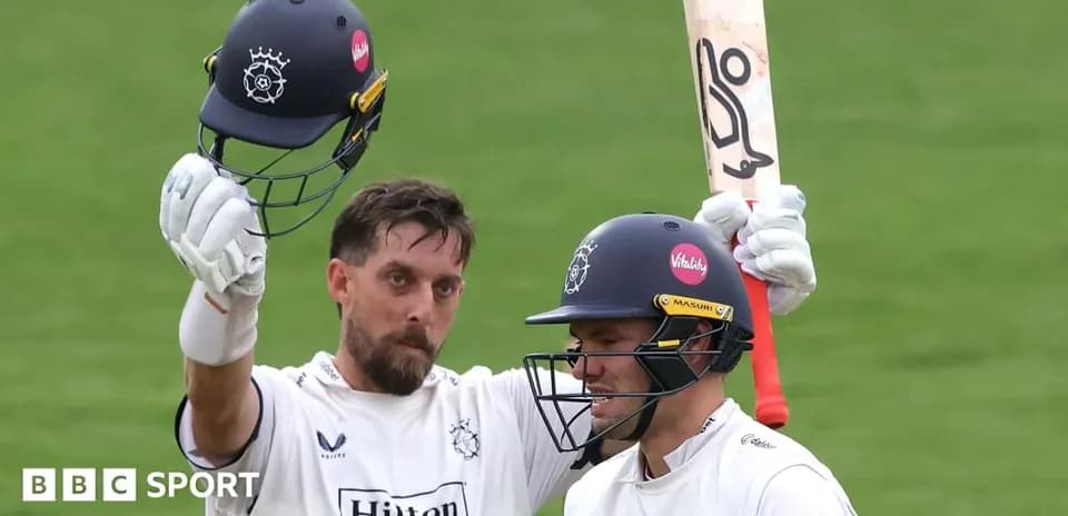 Cricketer celebrating a milestone with teammate